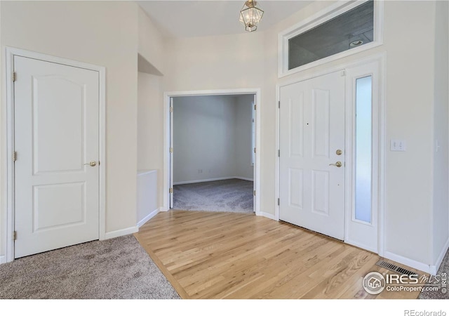 entryway featuring hardwood / wood-style flooring and a notable chandelier