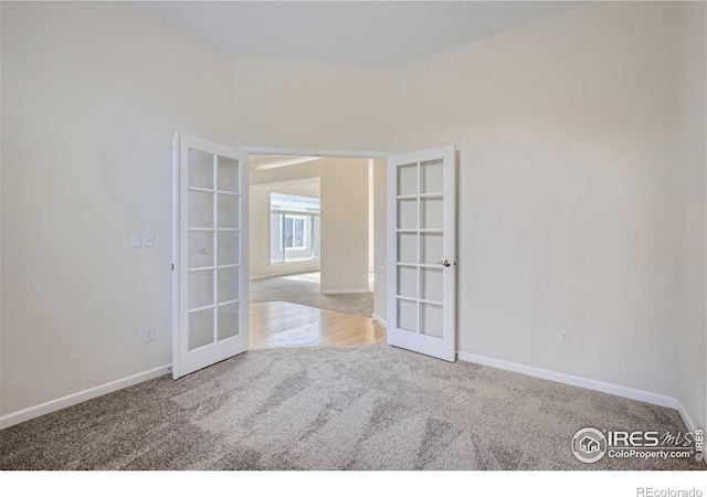 carpeted spare room with french doors