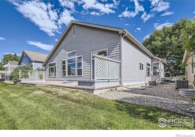 back of property featuring a yard and cooling unit