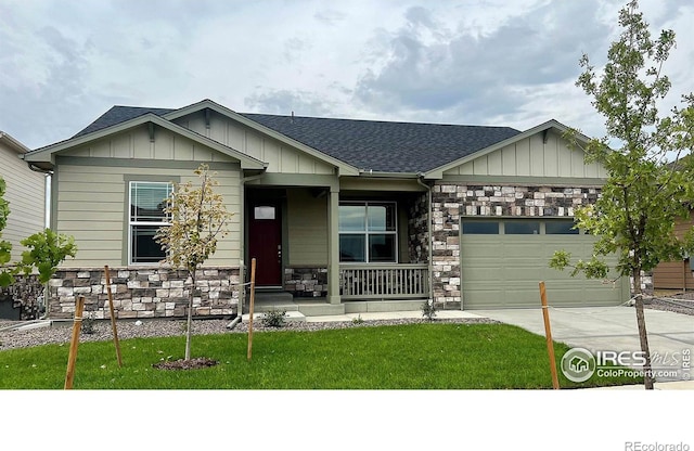 view of front of house with covered porch, a front yard, and a garage