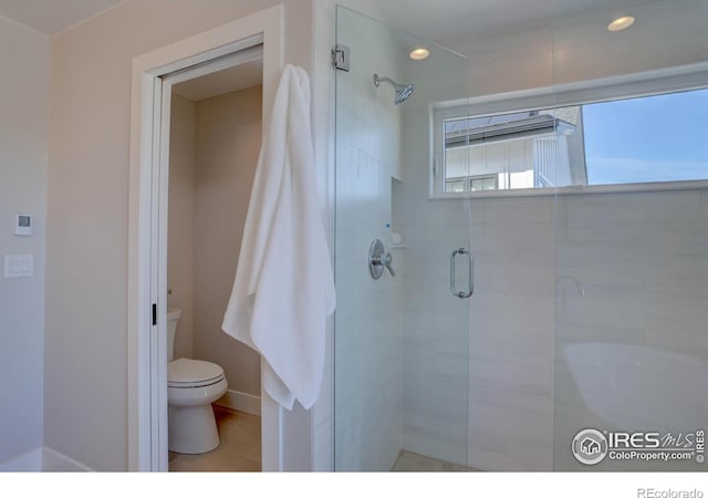 bathroom with an enclosed shower and toilet