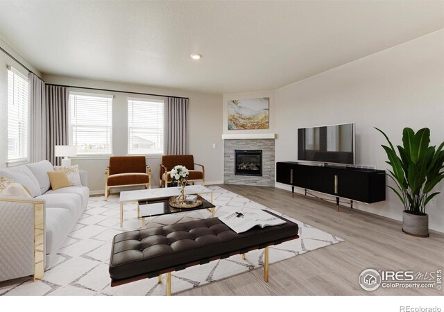 living room featuring light hardwood / wood-style floors, a wealth of natural light, and a tiled fireplace