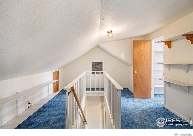 interior space featuring carpet floors, a textured ceiling, and vaulted ceiling