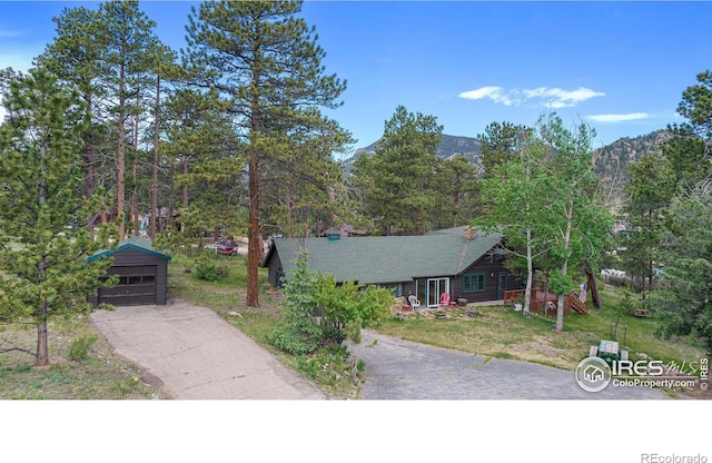 view of front of property with a mountain view, an outbuilding, a garage, and a front yard