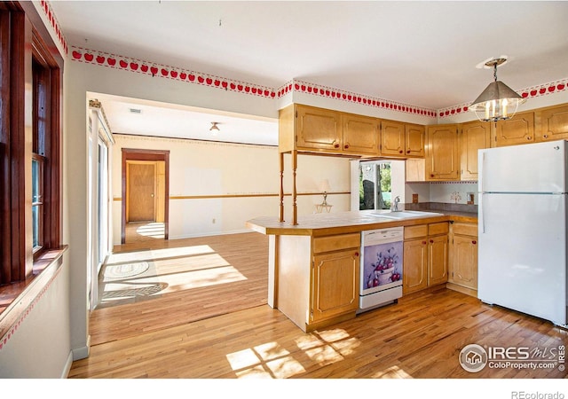 kitchen featuring sink, kitchen peninsula, pendant lighting, light hardwood / wood-style floors, and white appliances