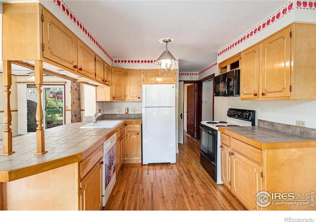 kitchen featuring tile countertops, sink, black appliances, and light hardwood / wood-style floors