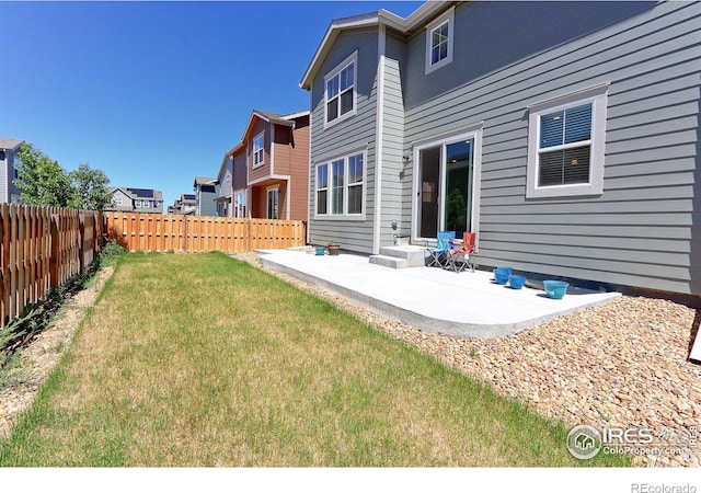 rear view of house featuring a lawn and a patio area