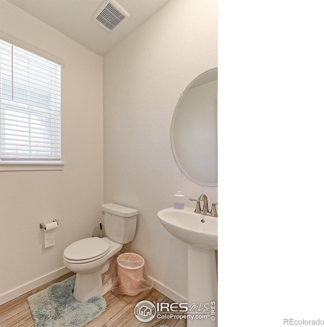 bathroom featuring hardwood / wood-style flooring and toilet