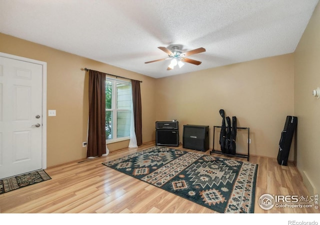 office with ceiling fan, a textured ceiling, and wood finished floors