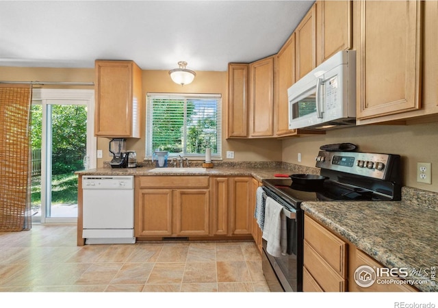 kitchen featuring white appliances, visible vents, and a sink