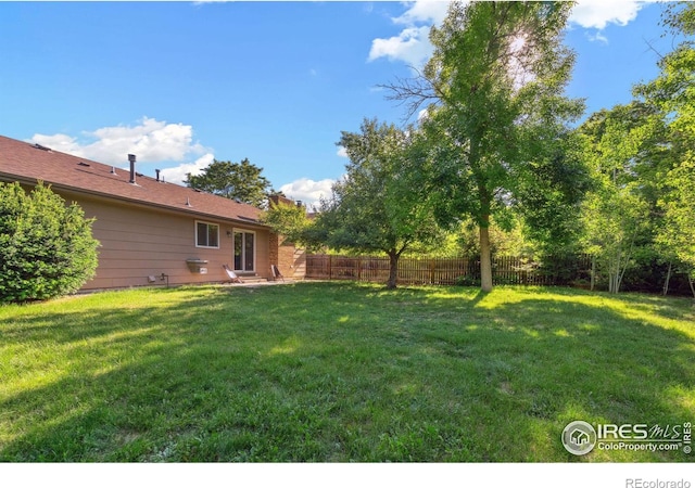 view of yard featuring entry steps and fence