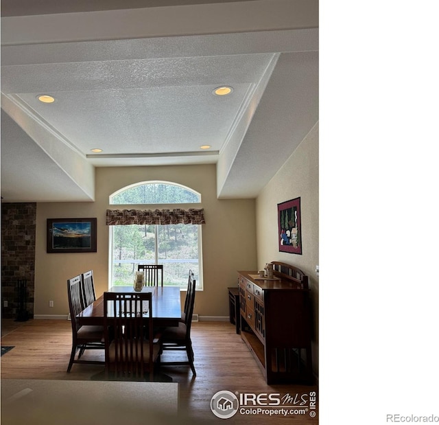 dining space with hardwood / wood-style floors and a textured ceiling