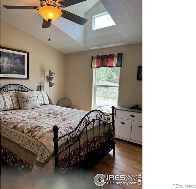 bedroom with ceiling fan, vaulted ceiling, and wood-type flooring