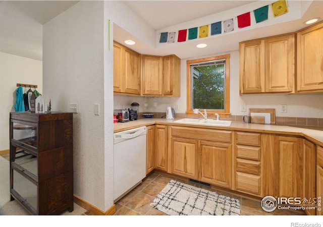 kitchen featuring white dishwasher, recessed lighting, a sink, visible vents, and light countertops