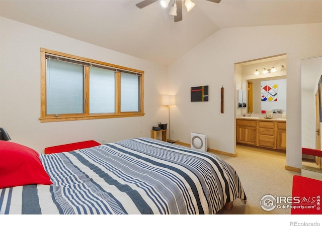 bedroom featuring light colored carpet, connected bathroom, vaulted ceiling, a sink, and baseboards