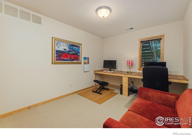 carpeted office space featuring visible vents and baseboards