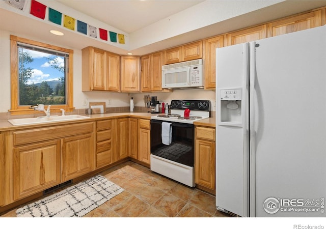 kitchen with white appliances, visible vents, vaulted ceiling, light countertops, and a sink