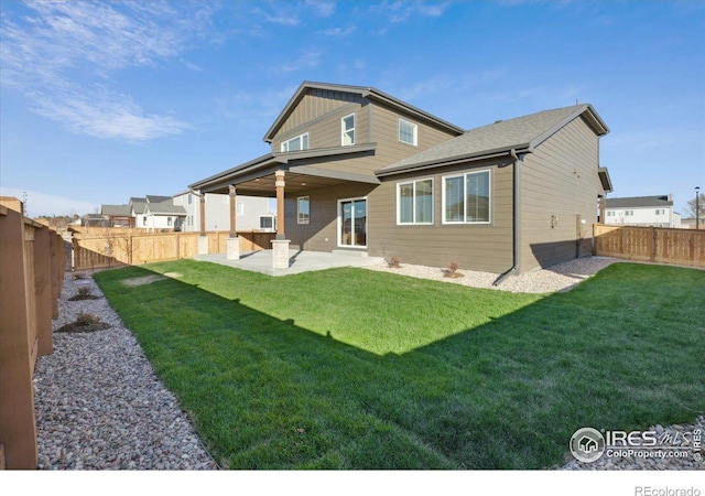 back of house featuring a lawn and a patio