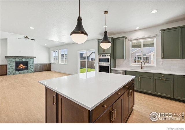 kitchen featuring plenty of natural light, lofted ceiling, sink, and hanging light fixtures