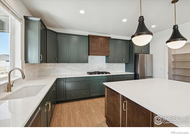 kitchen featuring decorative light fixtures, stainless steel appliances, plenty of natural light, and sink