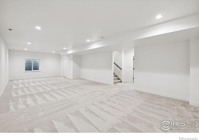 basement featuring light carpet