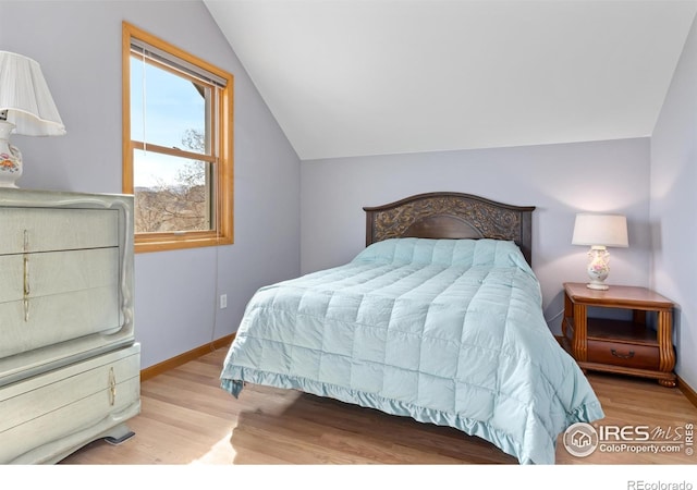 bedroom featuring vaulted ceiling and light hardwood / wood-style floors