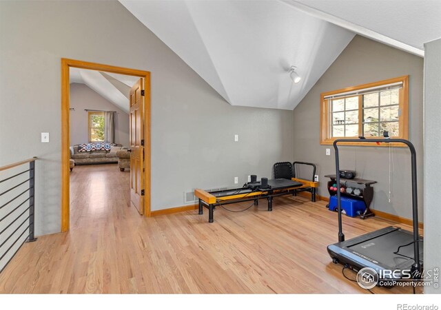 workout room featuring light hardwood / wood-style flooring and lofted ceiling