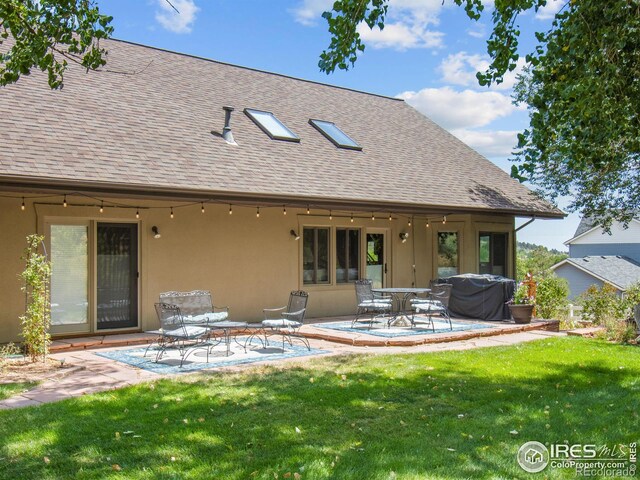 back of house featuring a patio and a yard