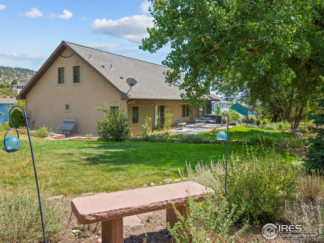 back of house with a patio and a yard