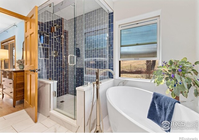 bathroom with tile patterned floors, shower with separate bathtub, and vanity