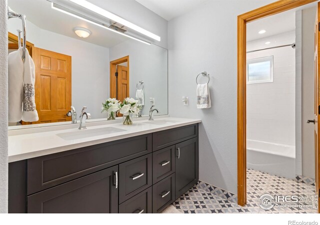 bathroom featuring double vanity, tile patterned floors, and bathing tub / shower combination