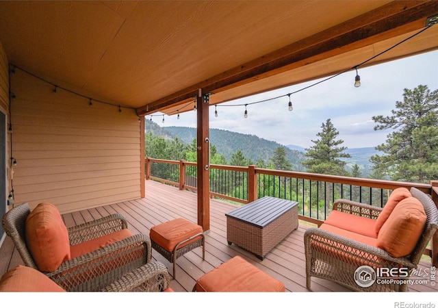 wooden deck with an outdoor living space and a mountain view