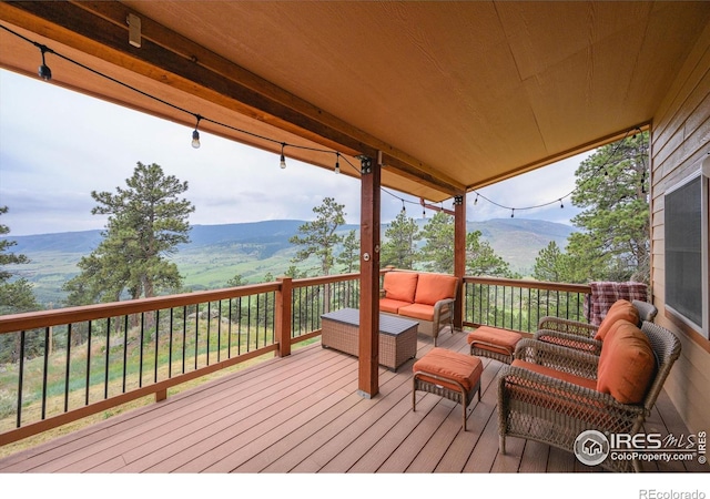 wooden terrace with a mountain view and outdoor lounge area