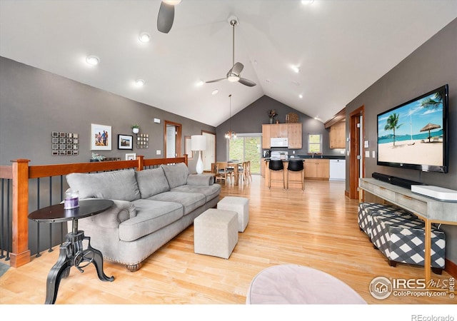 living room with lofted ceiling, sink, light hardwood / wood-style flooring, and ceiling fan