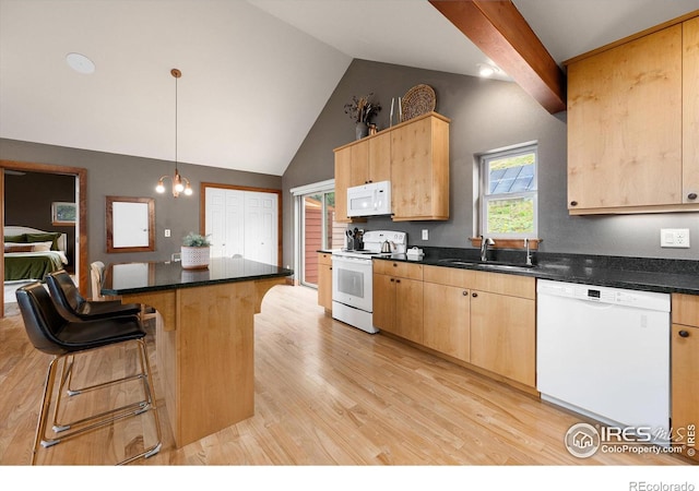 kitchen with white appliances, light brown cabinetry, sink, and hanging light fixtures