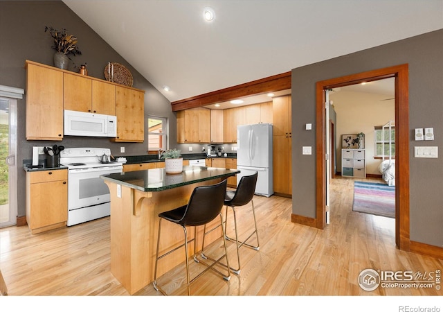 kitchen with high vaulted ceiling, light wood-type flooring, a kitchen breakfast bar, a kitchen island, and white appliances