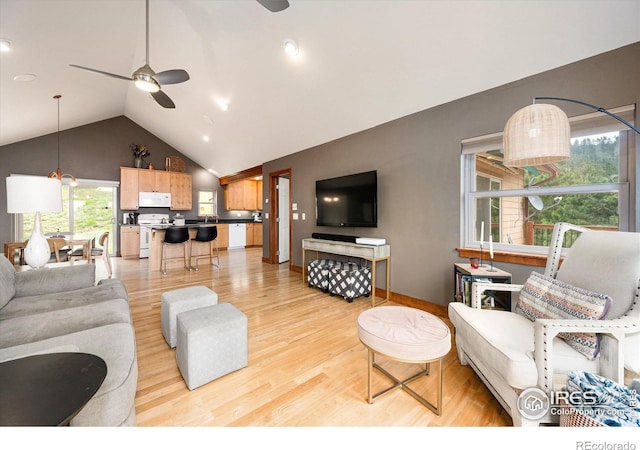 living room featuring ceiling fan, lofted ceiling, sink, and light hardwood / wood-style flooring