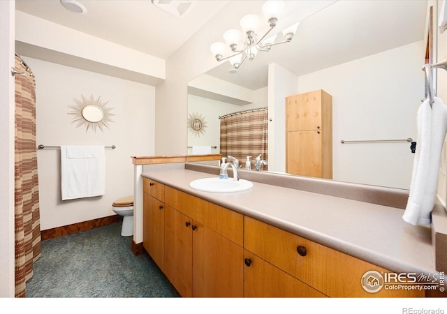 bathroom featuring vanity, an inviting chandelier, and toilet