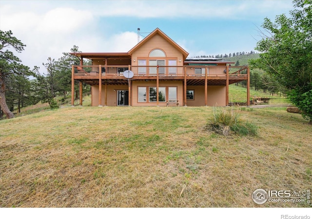 rear view of house with a deck and a lawn