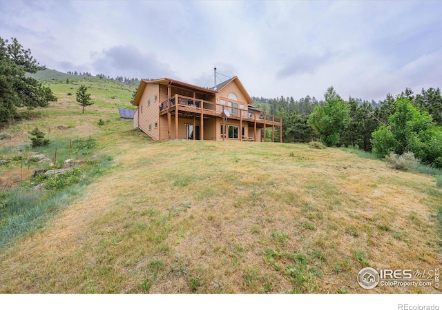 rear view of property featuring a yard and a deck