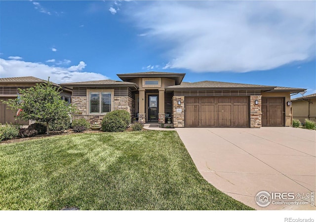 prairie-style home with a front yard and a garage