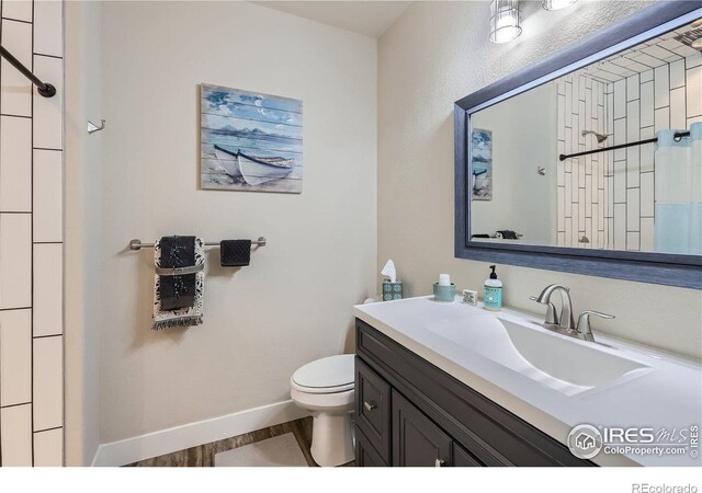 bathroom with vanity, toilet, and wood-type flooring