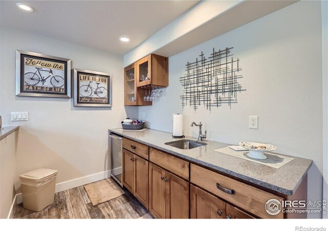 kitchen featuring light stone countertops, sink, and dark wood-type flooring