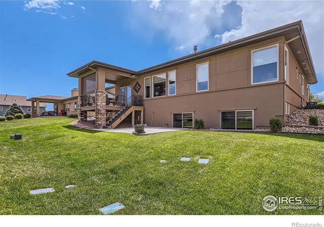 rear view of property with a patio area, a yard, and a wooden deck