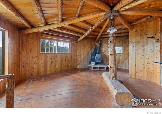 interior space with a wood stove, wooden ceiling, beamed ceiling, wooden walls, and hardwood / wood-style flooring