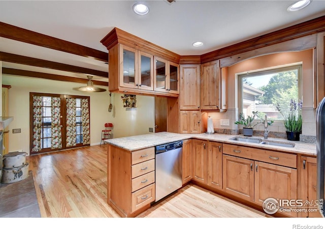 kitchen with light stone counters, sink, stainless steel dishwasher, and light hardwood / wood-style floors