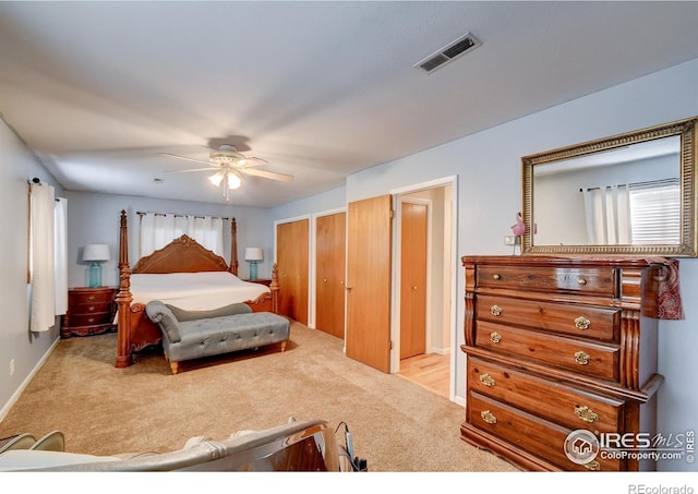 carpeted bedroom featuring two closets and ceiling fan