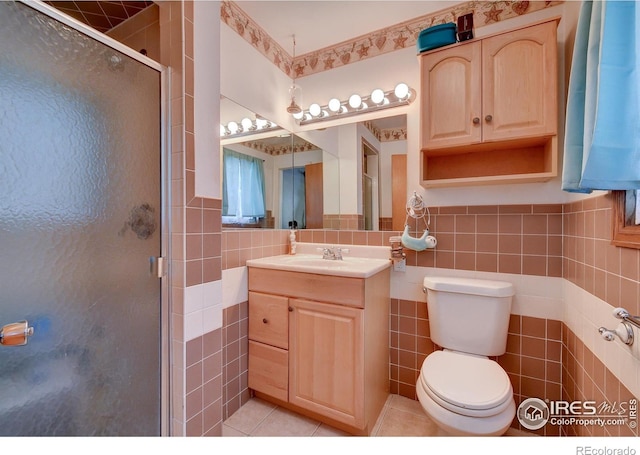 bathroom featuring toilet, tile patterned floors, tile walls, and a shower with shower door