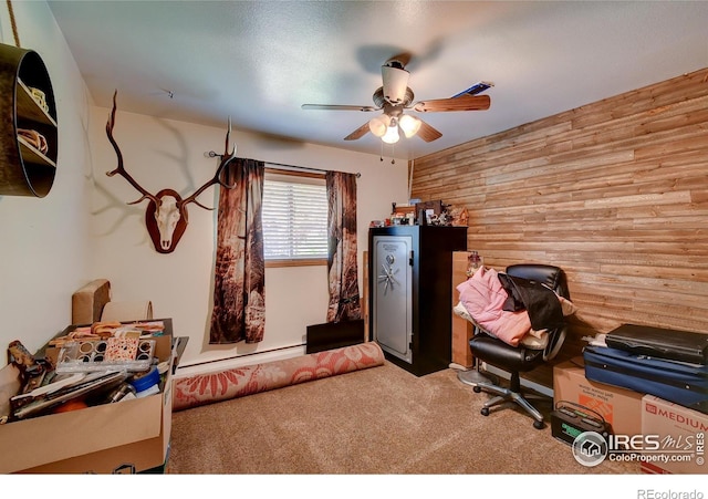 home office featuring ceiling fan, carpet floors, baseboard heating, and wooden walls