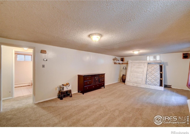 basement featuring light carpet, a textured ceiling, and a baseboard radiator